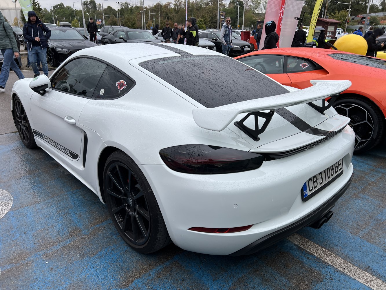 White coupe with large rear wing and black wheels