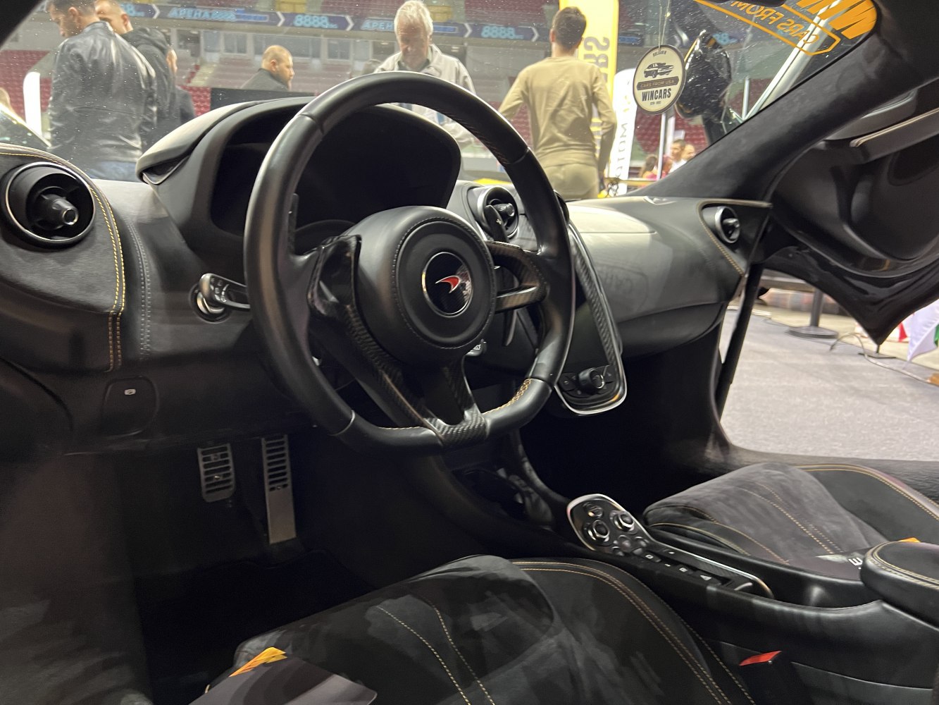Close-up interior with carbon fiber steering wheel and dashboard details