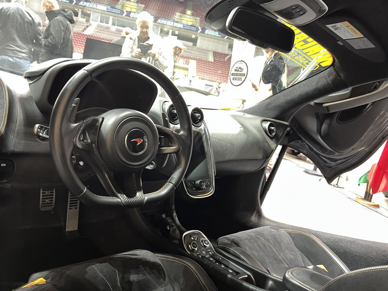 Carbon fiber steering wheel with modern dashboard and racing controls.