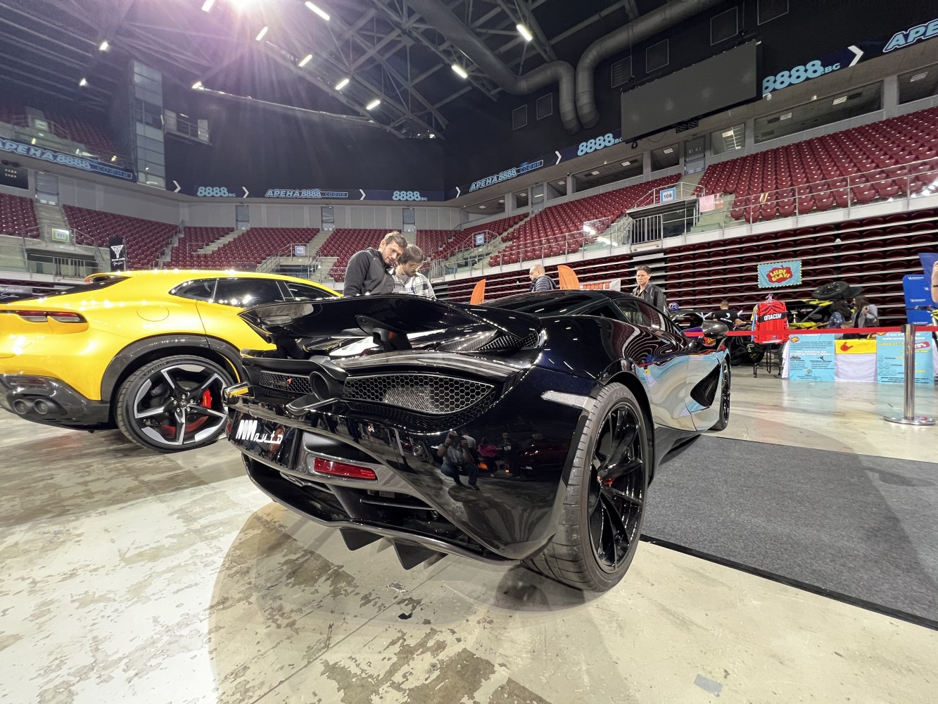 Glossy black supercar rear with aerodynamic design and performance exhausts
