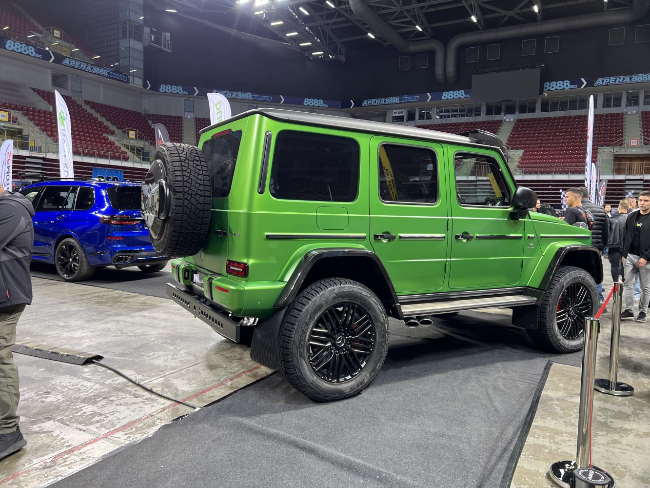 Green off-road SUV rear and side view with spare tire and black wheels