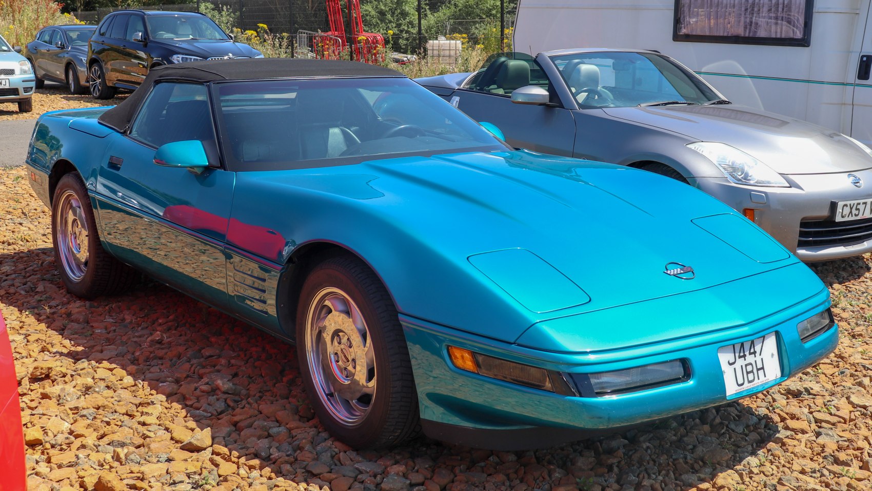 Blue convertible with black soft top and pop-up headlights
