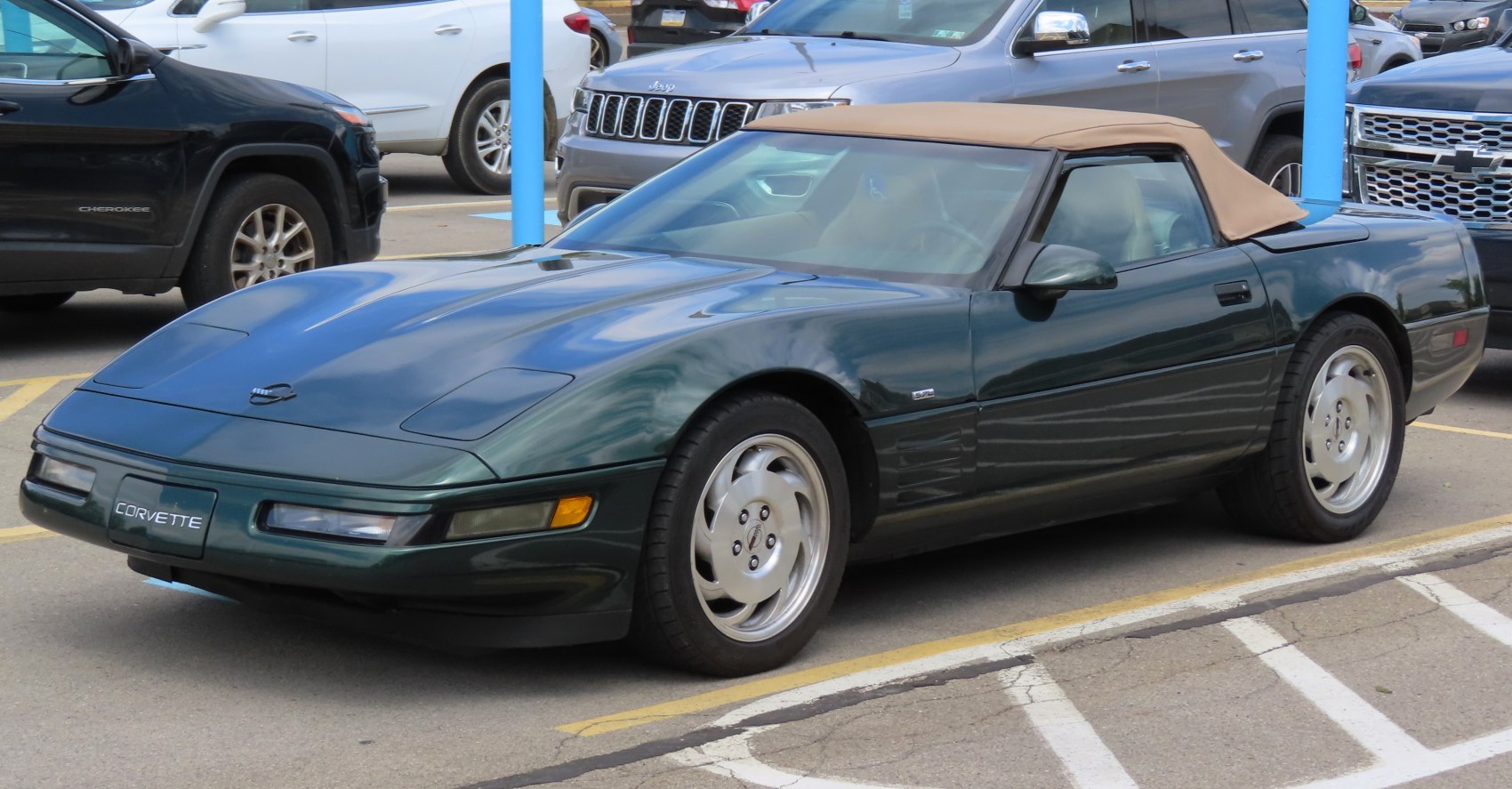 Convertible sports coupe with pop-up headlights and tan soft top