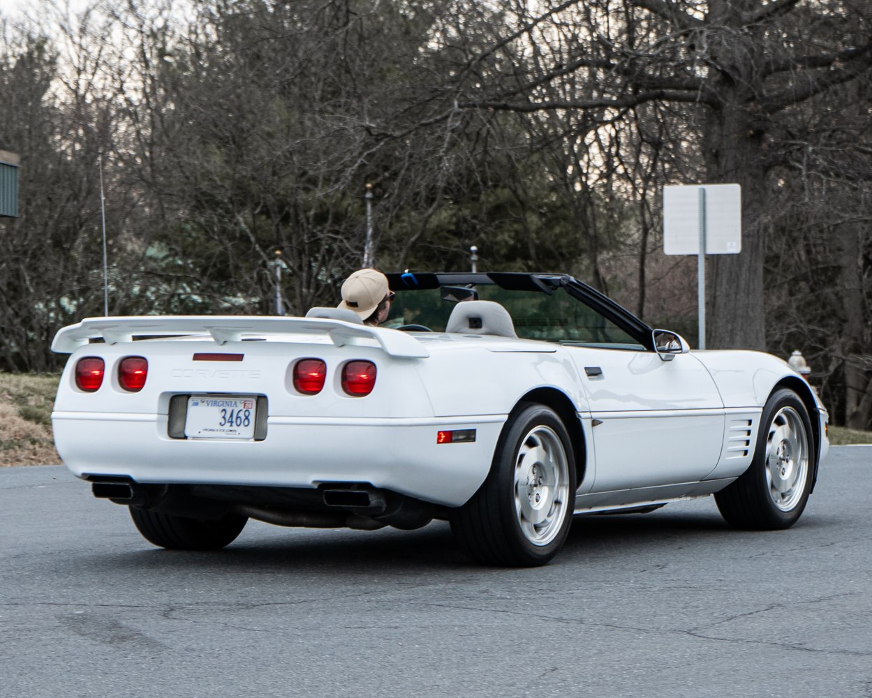 Rear view of white convertible with spoiler and quad round taillights