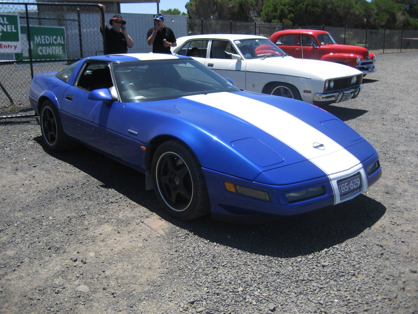 Blue sports coupe with white racing stripe and aerodynamic front