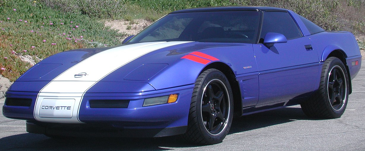 Sporty front view of a purple 1990s aerodynamic coupe with racing stripes