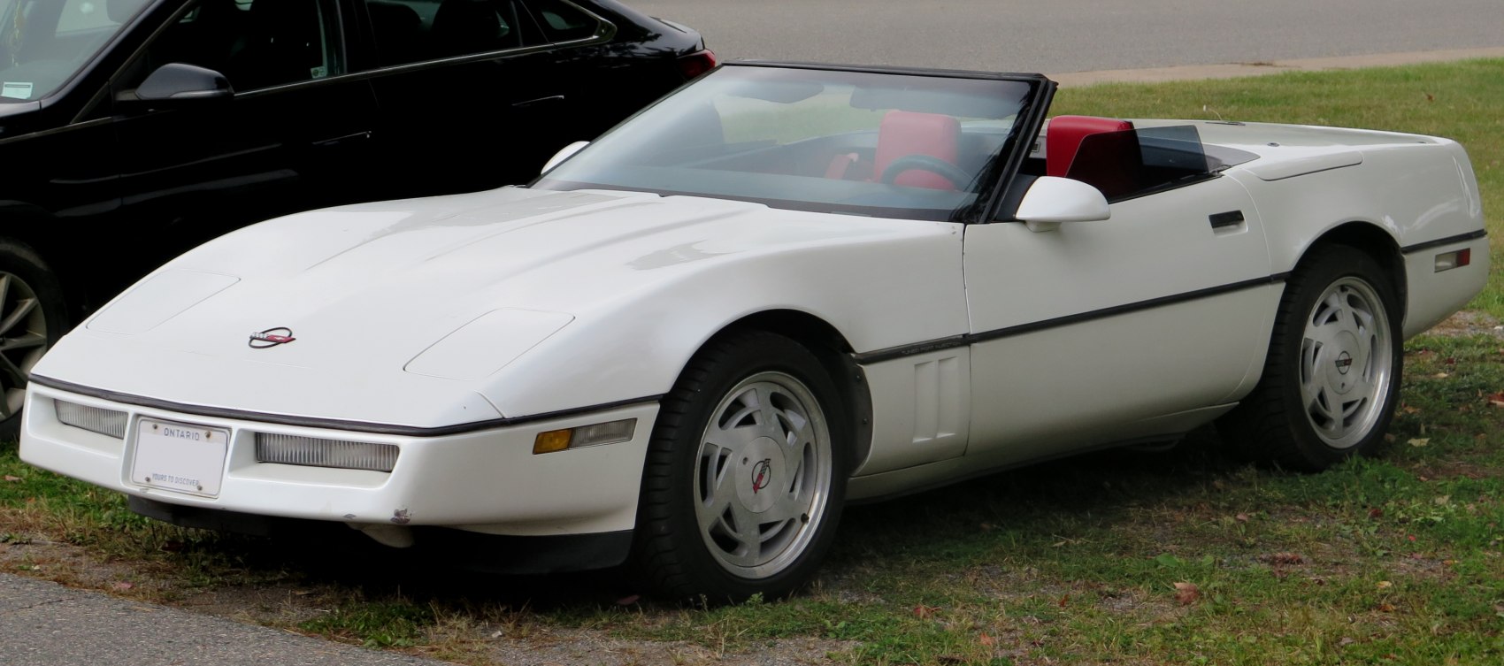 White convertible with pop-up headlights and red interior