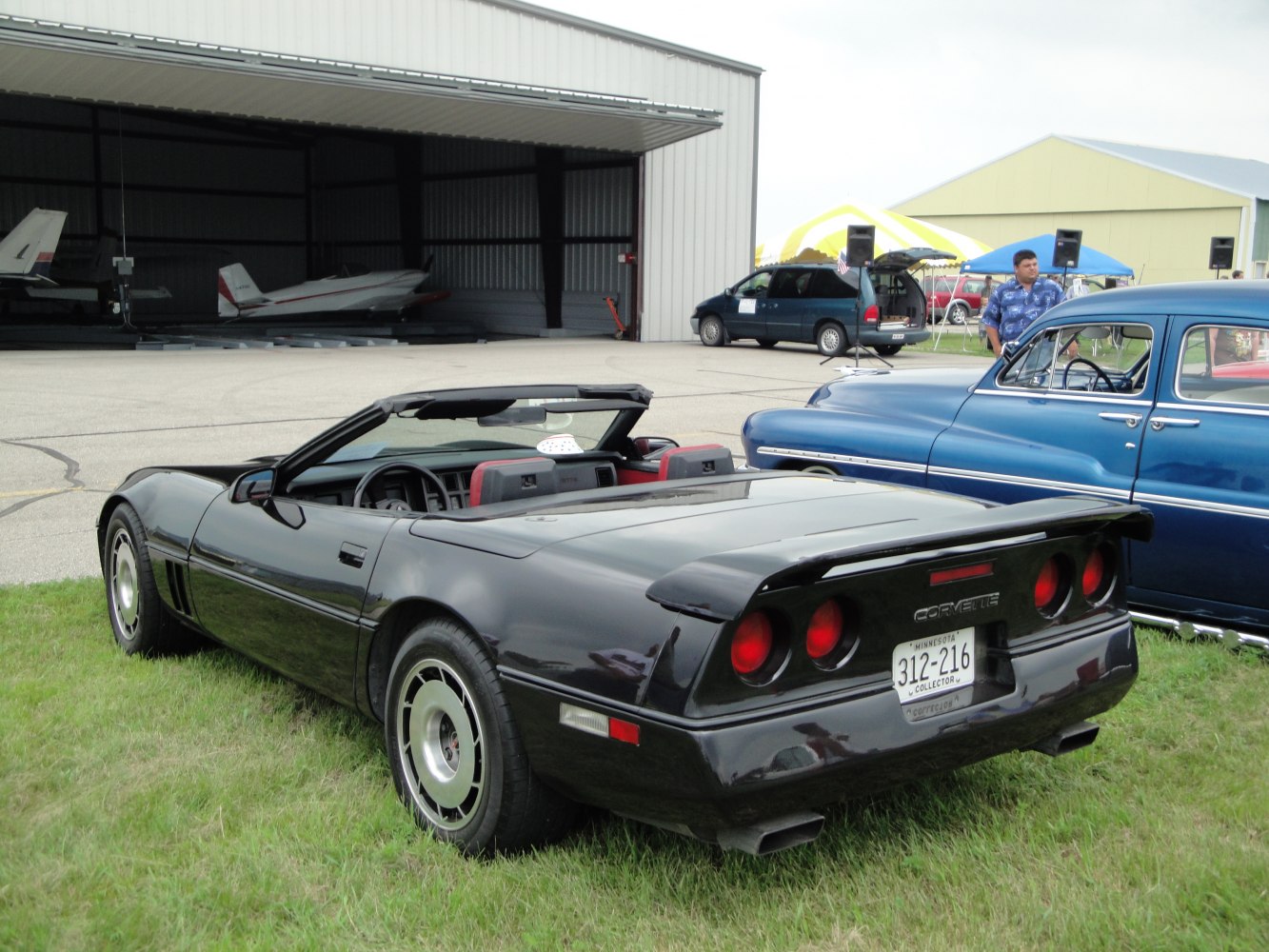 Convertible Corvette C4 in black showing rear and side view on grass