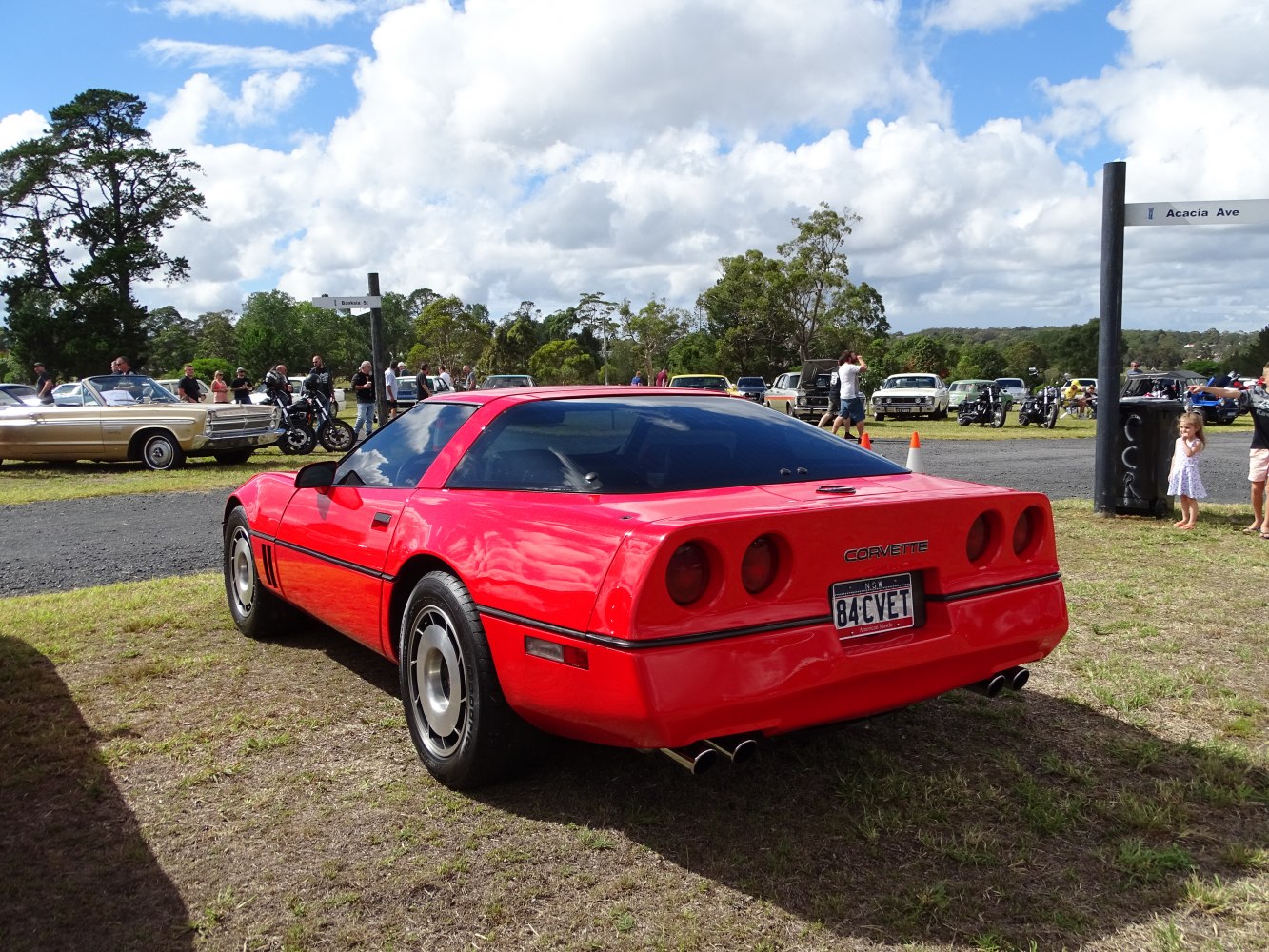Red sports coupe rear with four round taillights