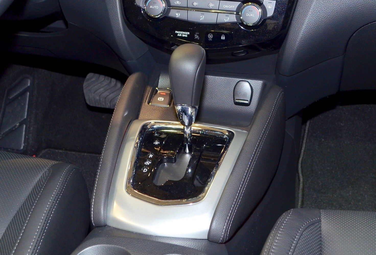 Automatic gear shift console with parking brake button and climate control panel above
