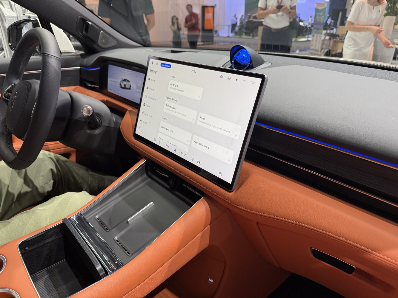 Large central touchscreen and digital driver display in orange leather interior