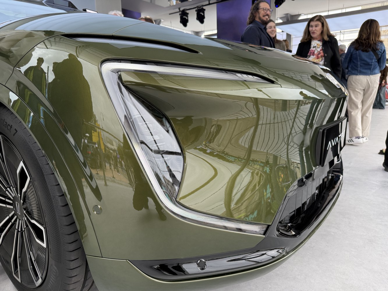 Close-up of futuristic front headlight and aerodynamic fender with detailed wheel design.