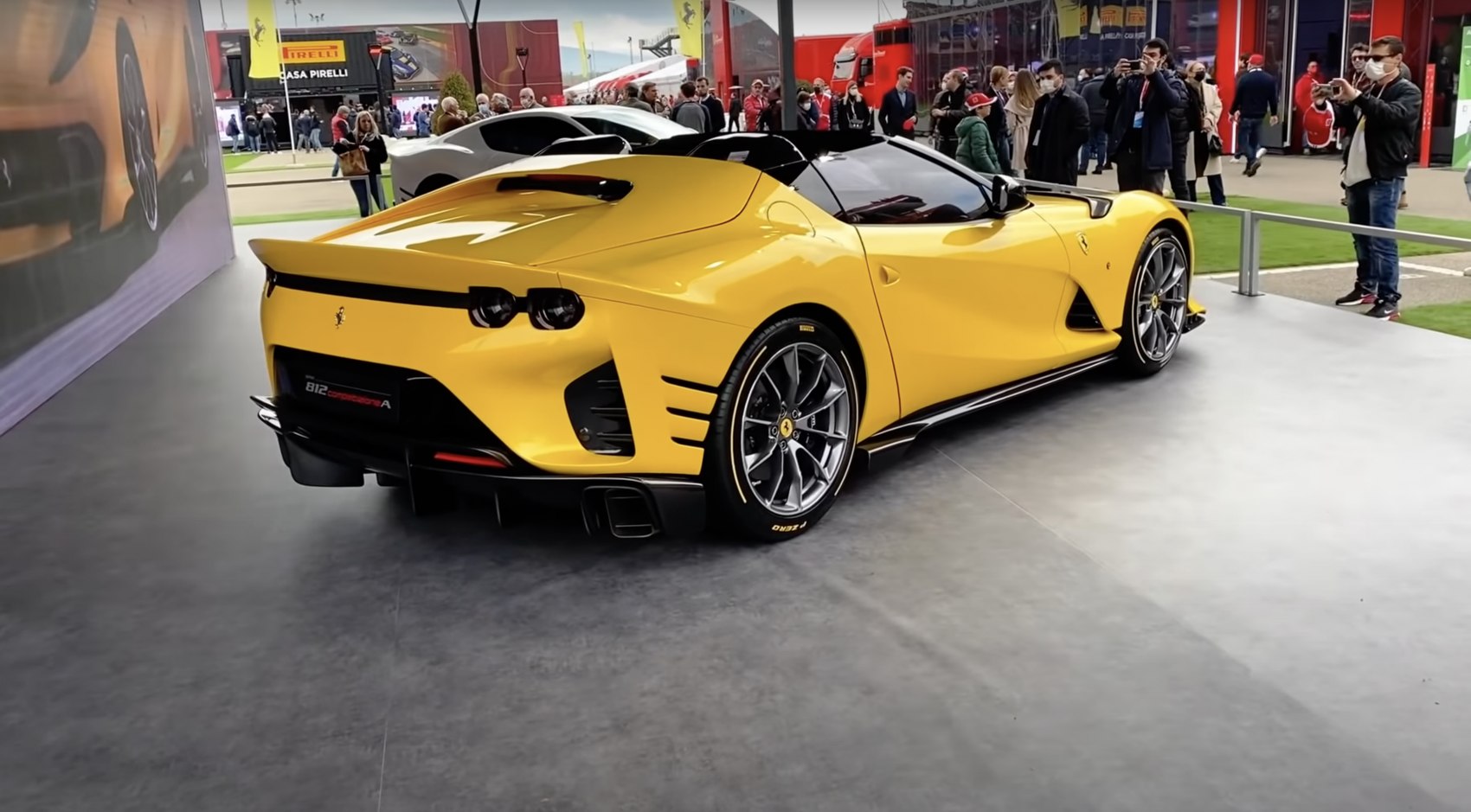 Rear three-quarter view of a yellow sports car with round taillights and aggressive diffuser.