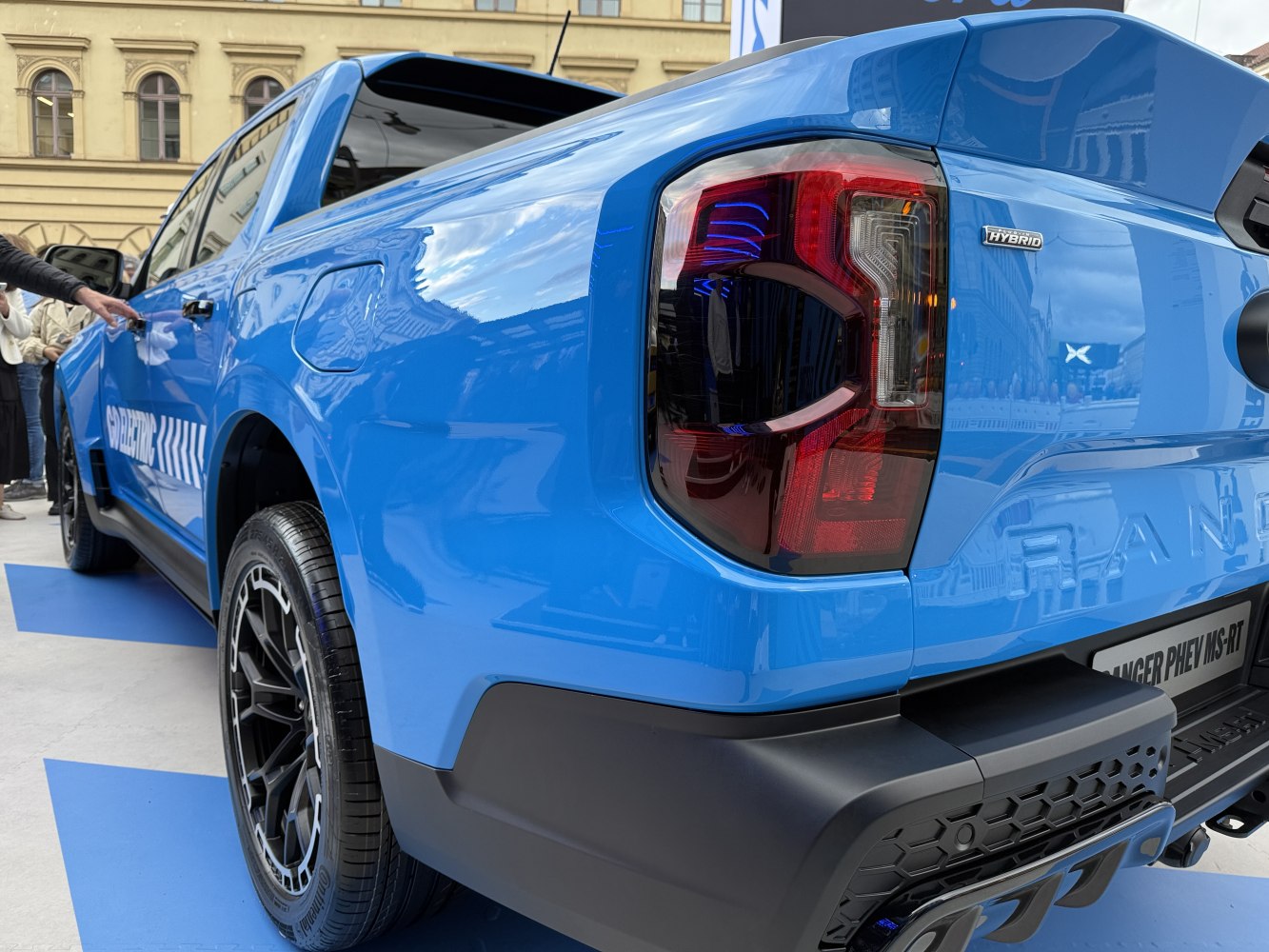 Blue pickup truck rear tail light and side profile with hybrid badge