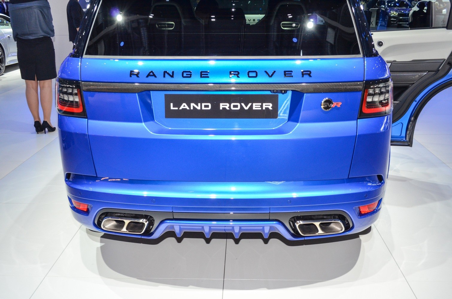 Rear view with quad exhaust tips, rear diffuser, distinctive tail lights, and open rear door.