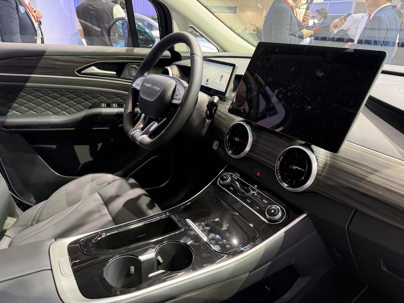 Leather steering wheel, dual touchscreens, woodgrain dashboard, modern control panel