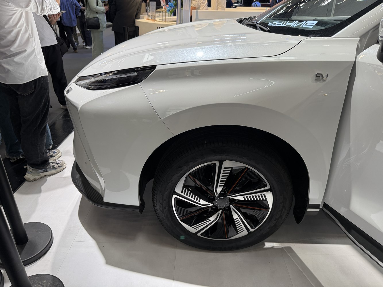 Front wheel and sleek headlight design of a white electric vehicle