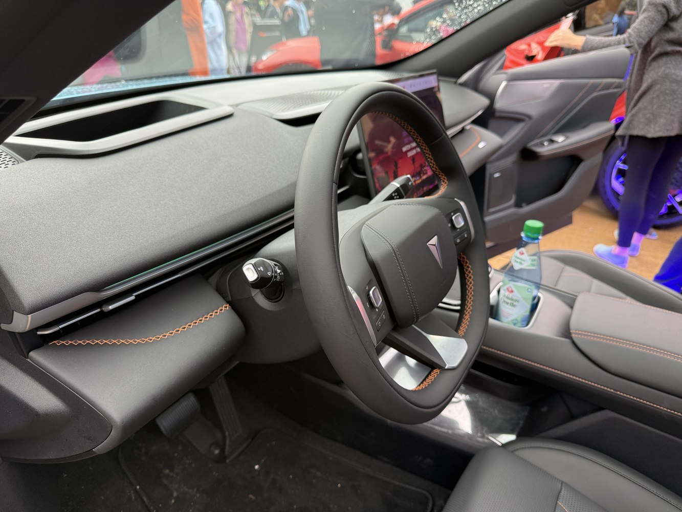 Modern steering wheel with orange stitching and digital instrument cluster