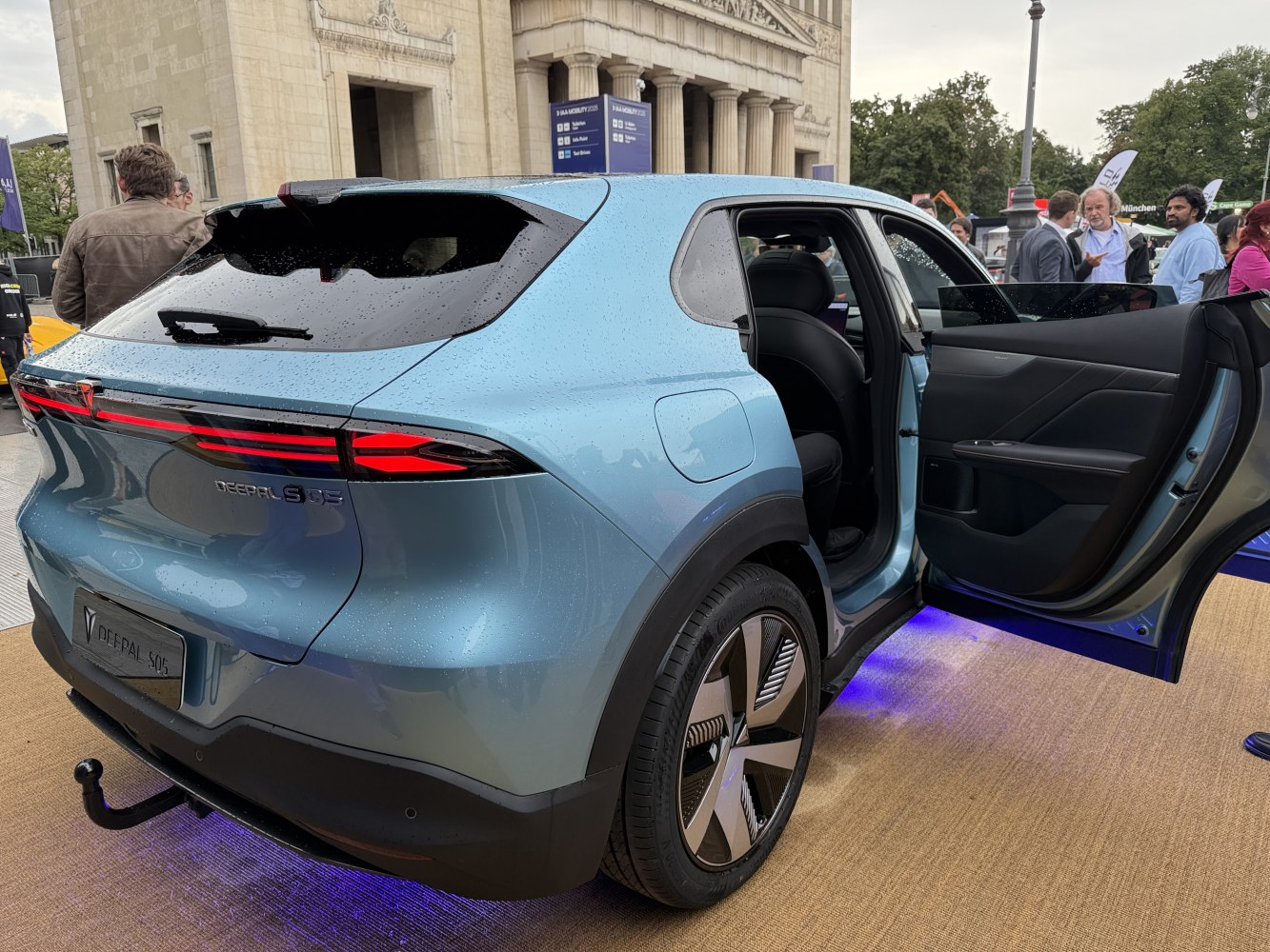 Futuristic LED taillights, unique wheel design, rear door open.