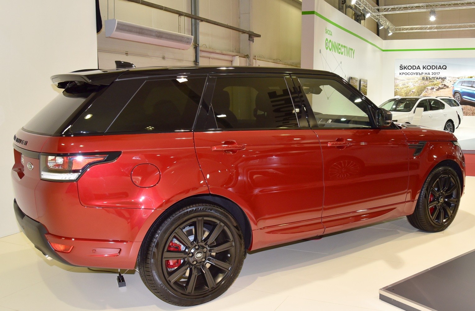 Red SUV with black roof, tinted windows, and black alloy sports wheels