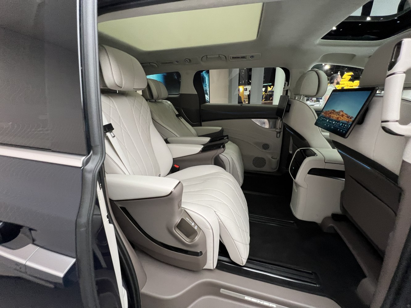 White leather reclining seats with rear entertainment screens in a luxury cabin