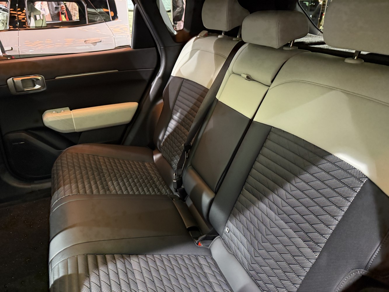 Quilted patterned two-tone leather rear seats with seatbelt and door panel.