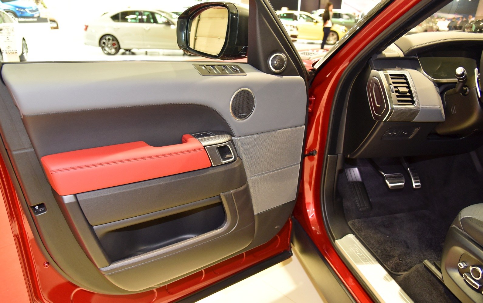 Interior door panel with red trim and driver foot pedals