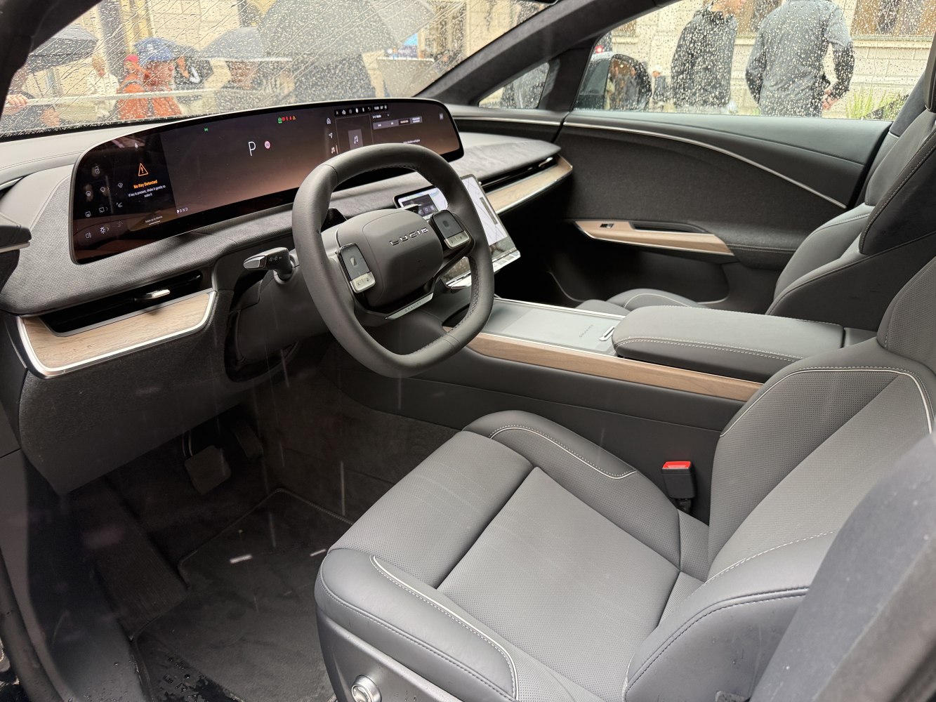 Wide digital dashboard and ergonomic seats in electric vehicle interior.