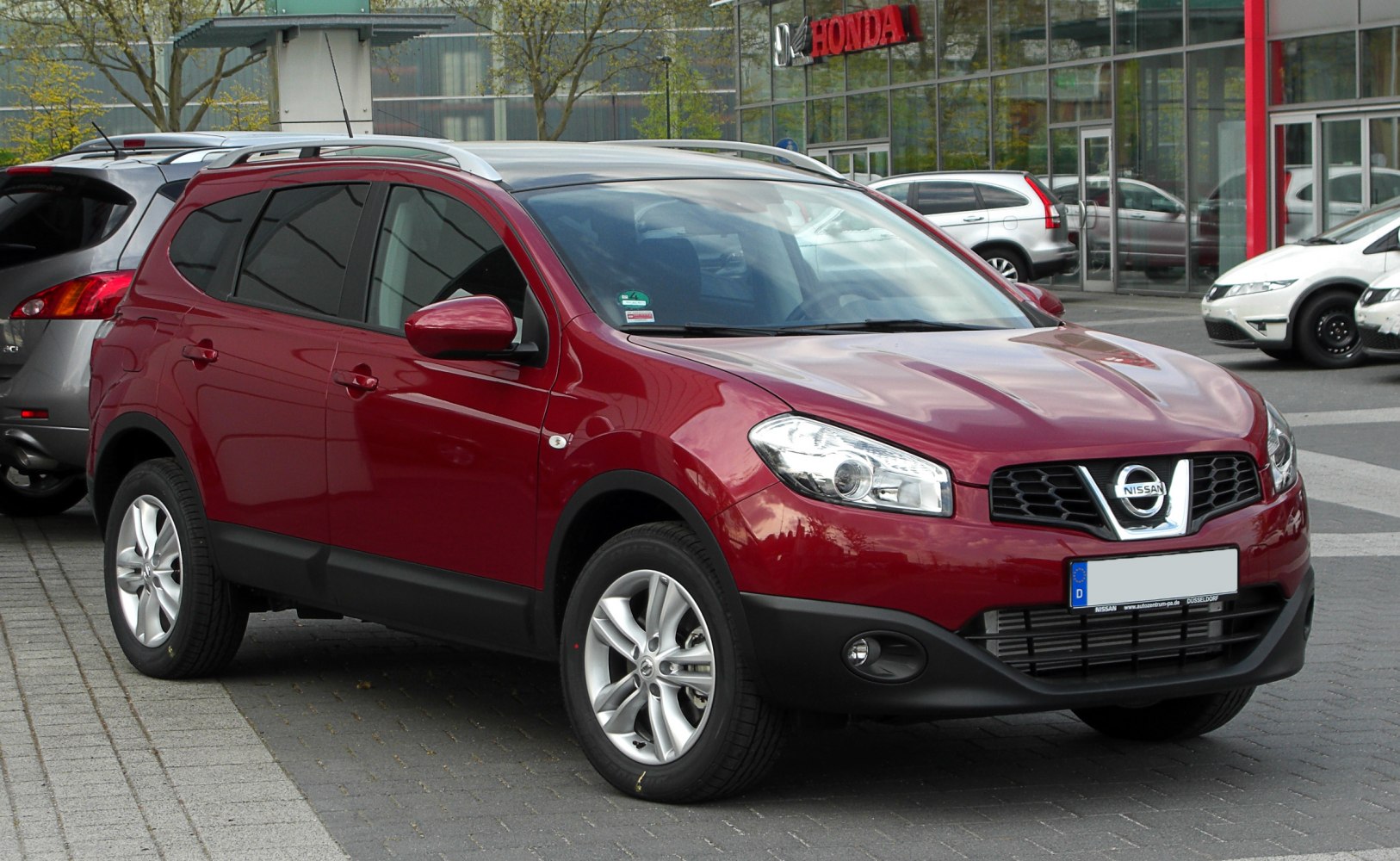Red compact SUV with alloy wheels and roof rails