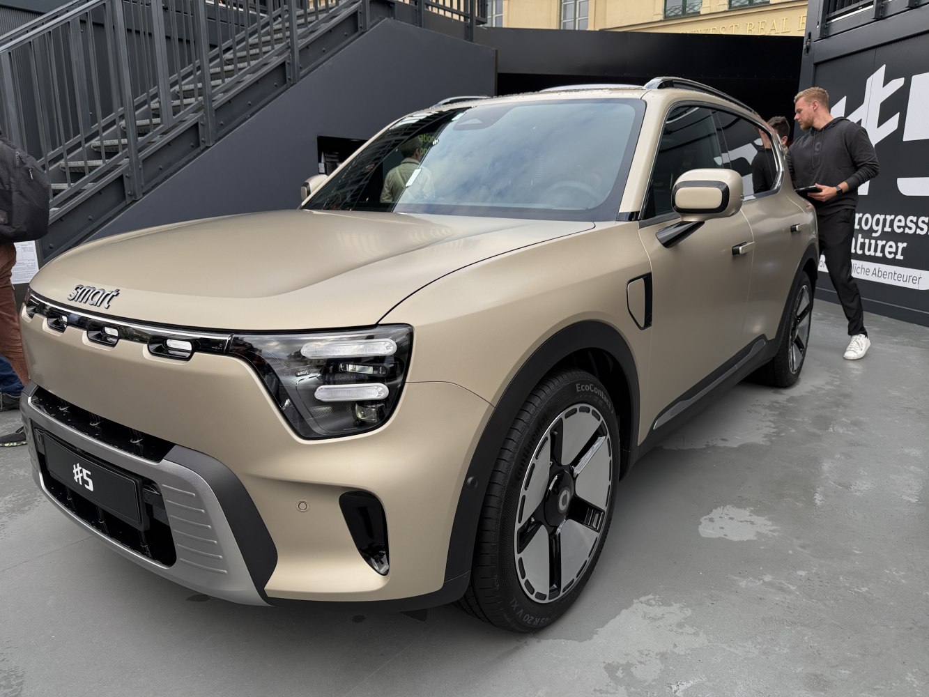 Front and side view of electric SUV with unique headlights and aerodynamic wheels.