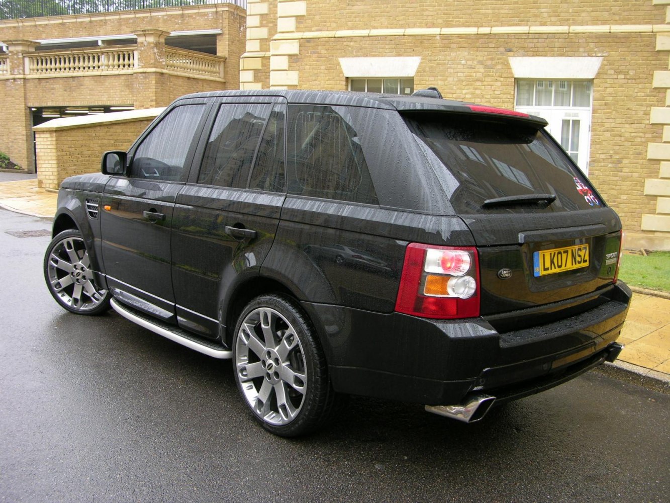 Rear and side view of a black SUV with alloy wheels.