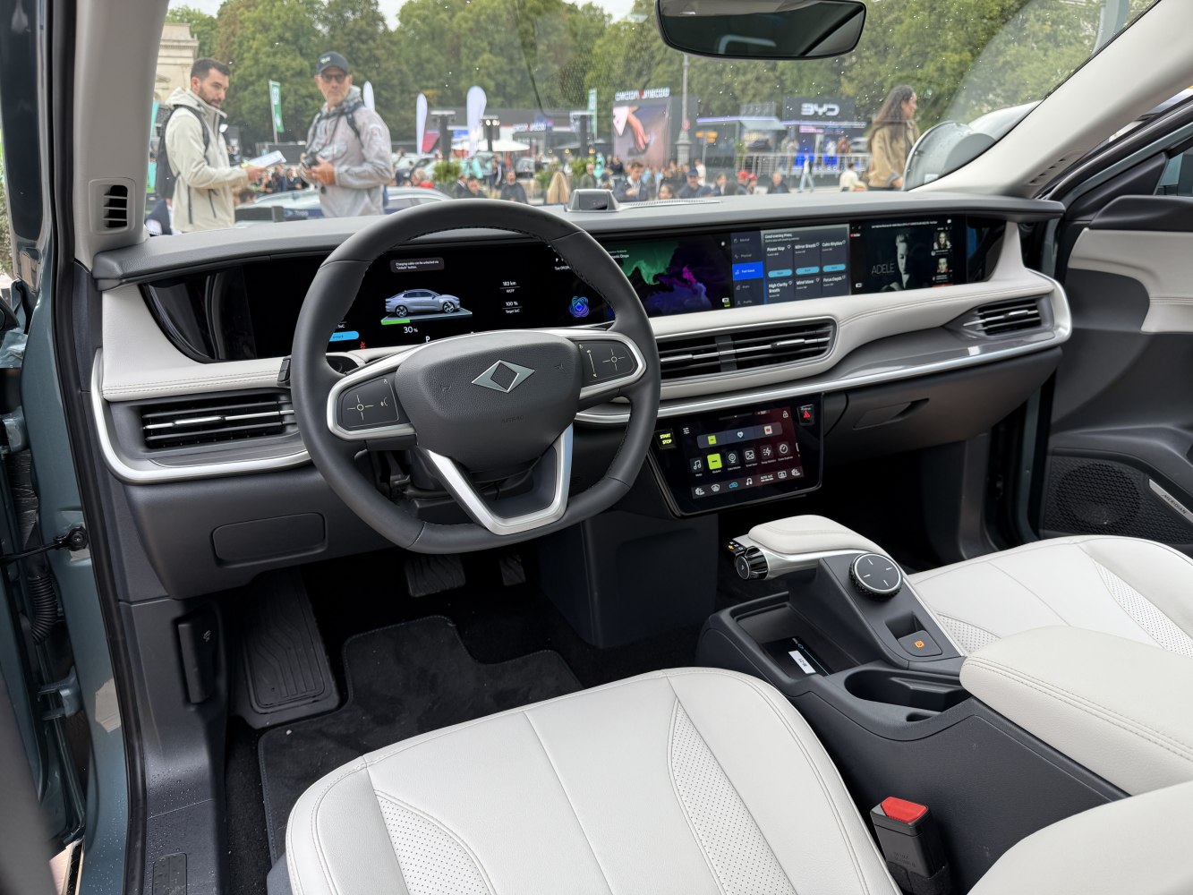 Advanced digital dashboard and steering wheel with multiple displays and white seats