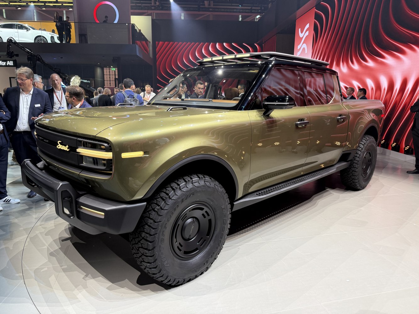 Electric pickup with off-road tires and roof rack in front-side view