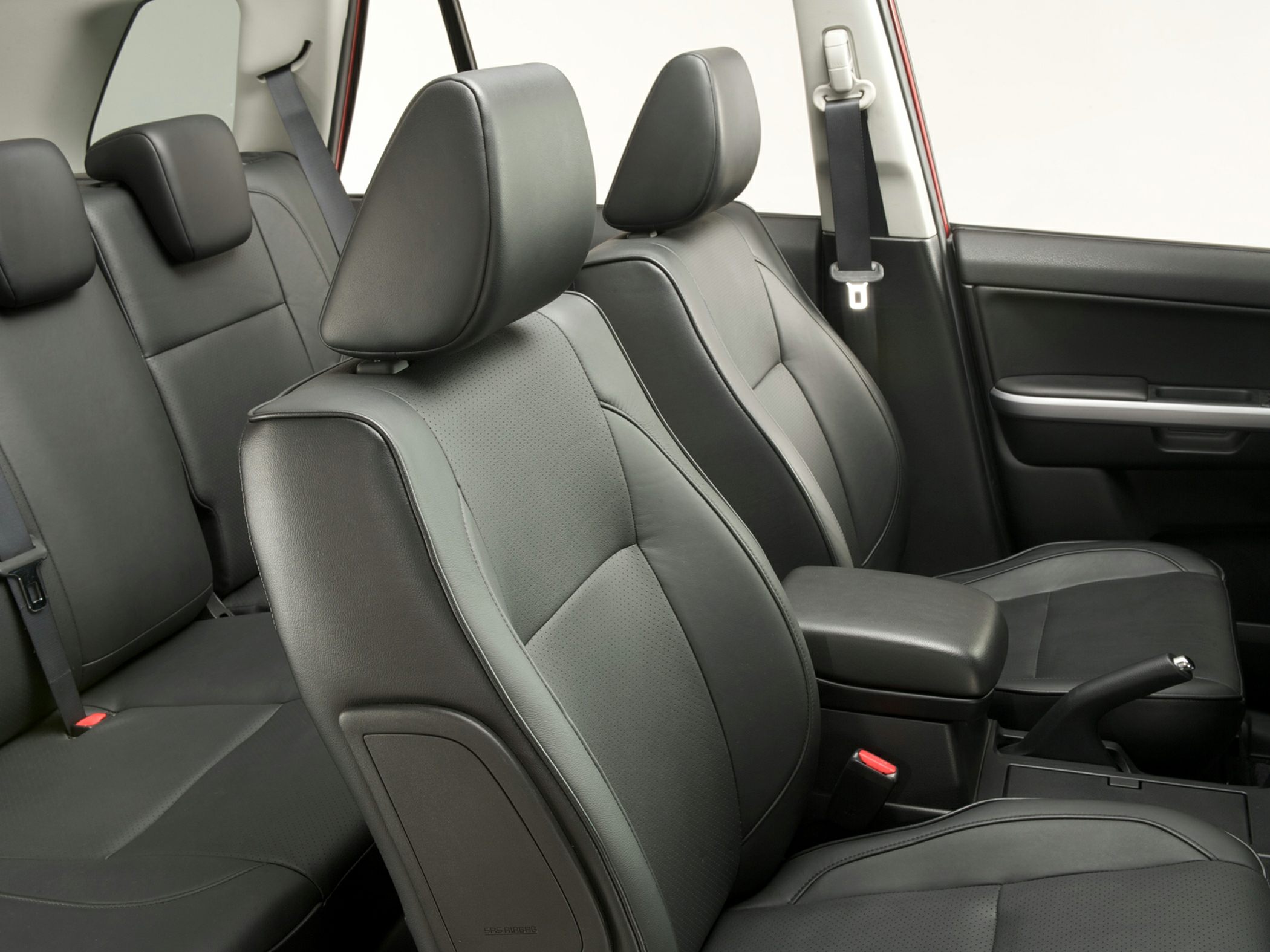 Black leather seating with armrest and seatbelts in car interior