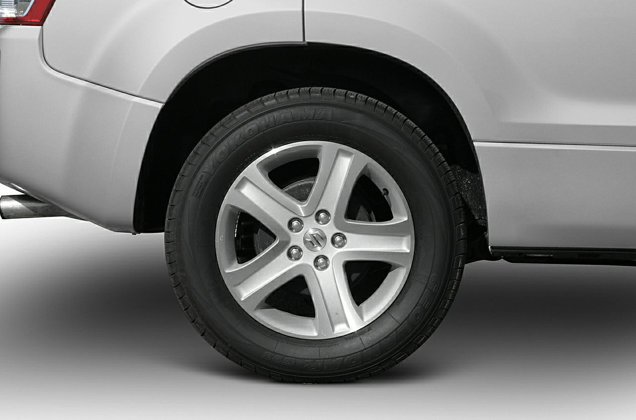 Silver alloy five-spoke wheel rim with Yokohama tire on vehicle rear.