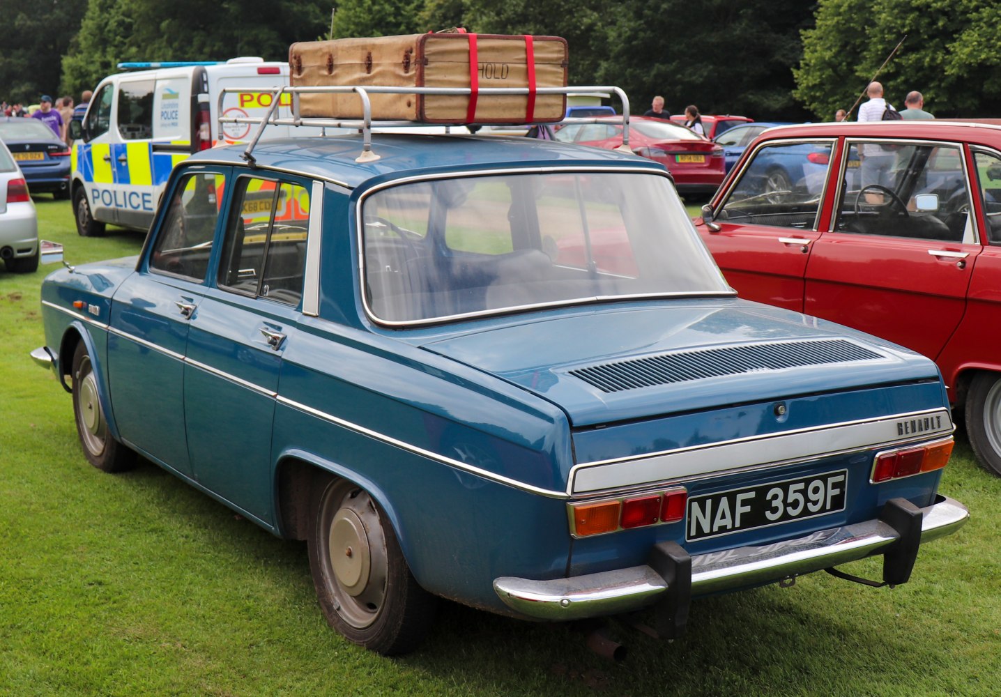 Rear view of vintage sedan with roof luggage rack and suitcase.