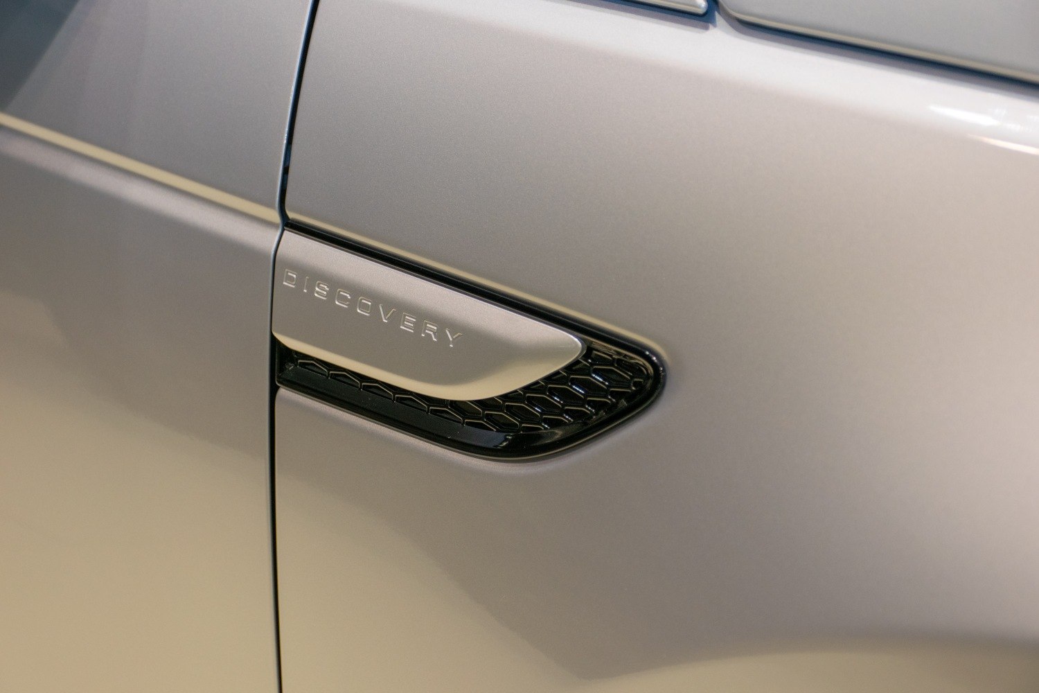 Close-up of side vent with 'DISCOVERY' lettering and hexagonal grille detail.