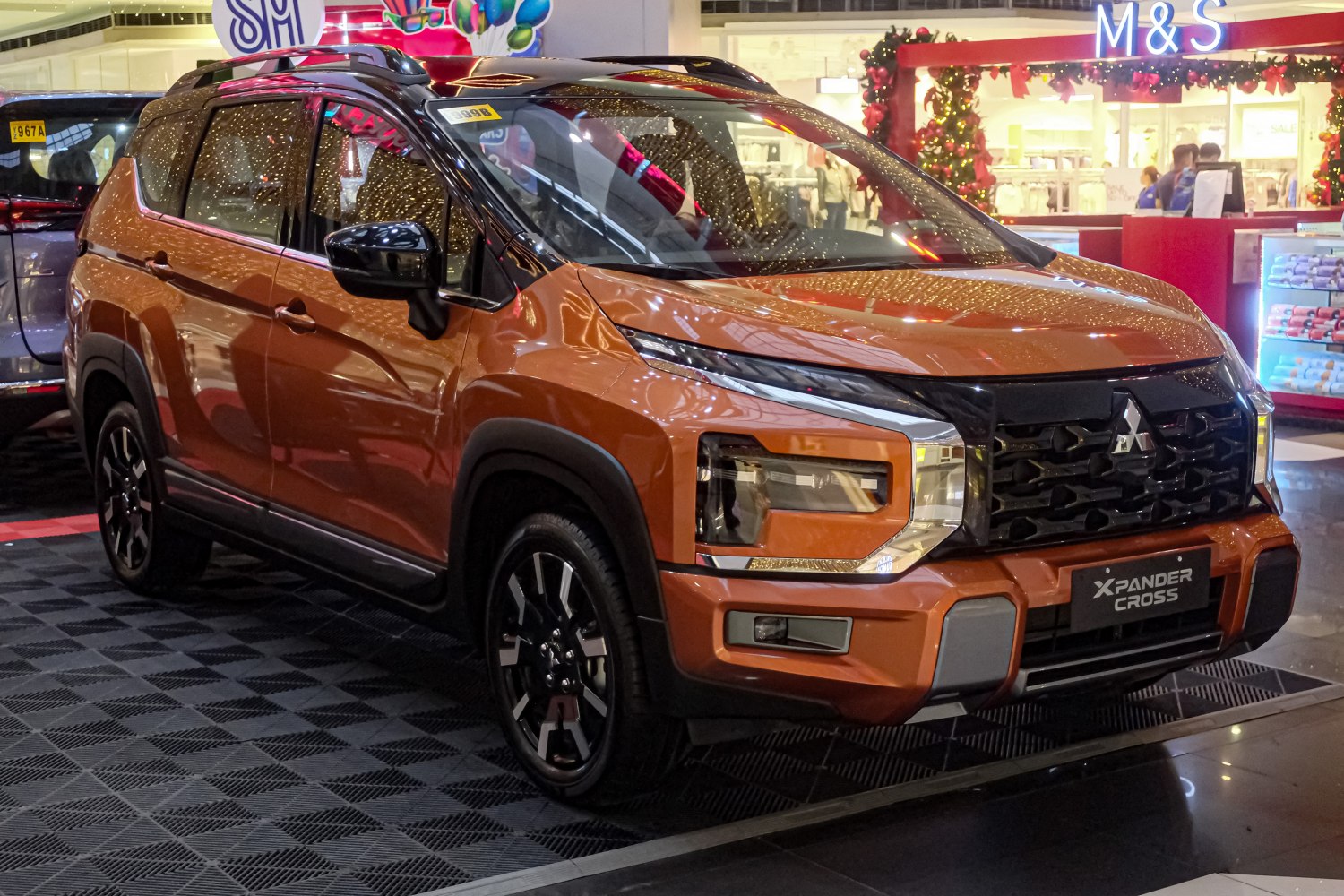 Front view of an orange SUV with dynamic headlights and rugged styling