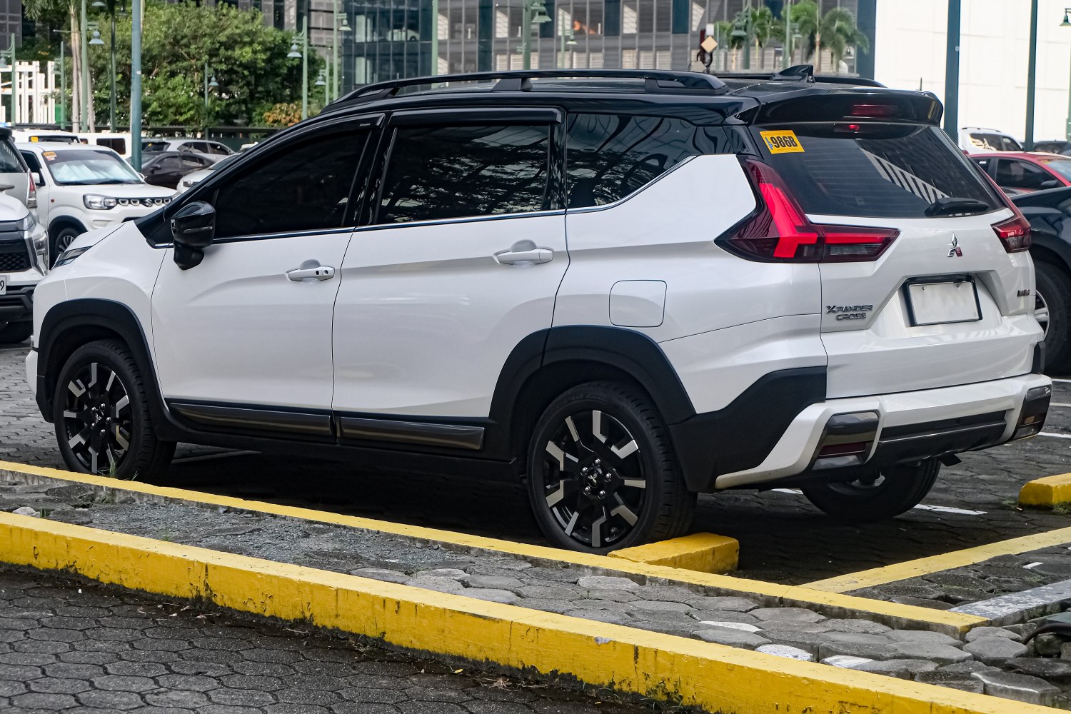 Rear and side view of a white SUV with black roof and distinctive tail lights.