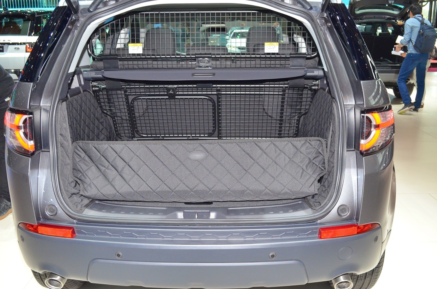SUV trunk with quilted protective liner and cargo mesh barrier.