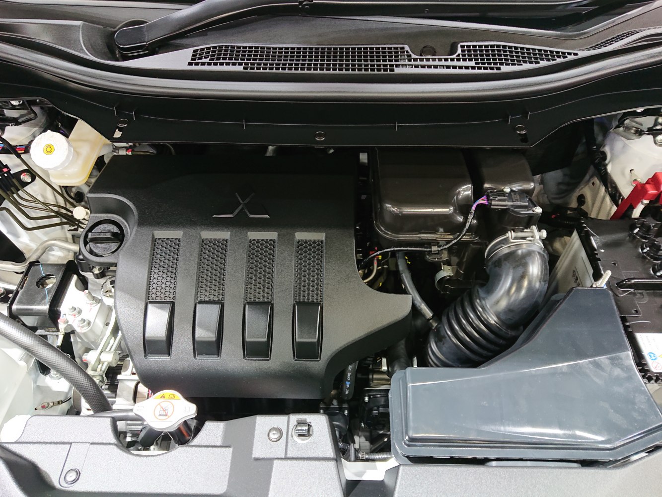Close-up of air intake system and engine cover in a modern vehicle engine bay