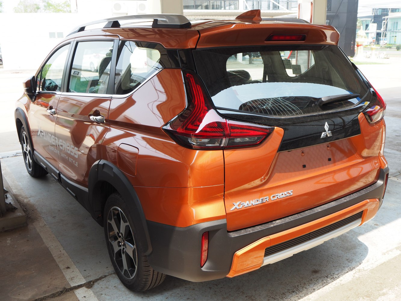 Rear and side view of an orange SUV with distinctive taillights and roof rails