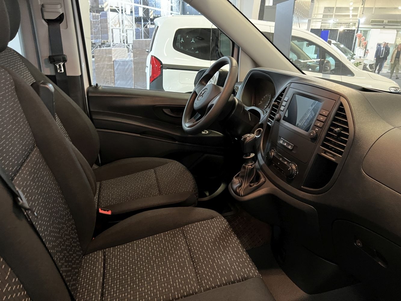 Interior front cabin with fabric seats, steering wheel, and dashboard