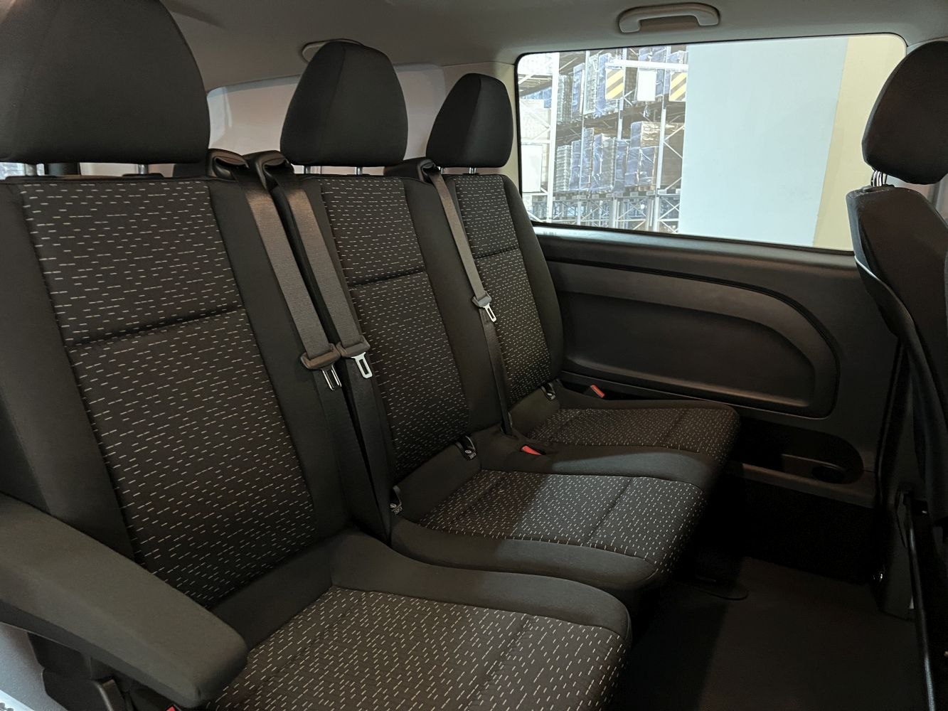 Spacious rear passenger seats with patterned upholstery and seat belts