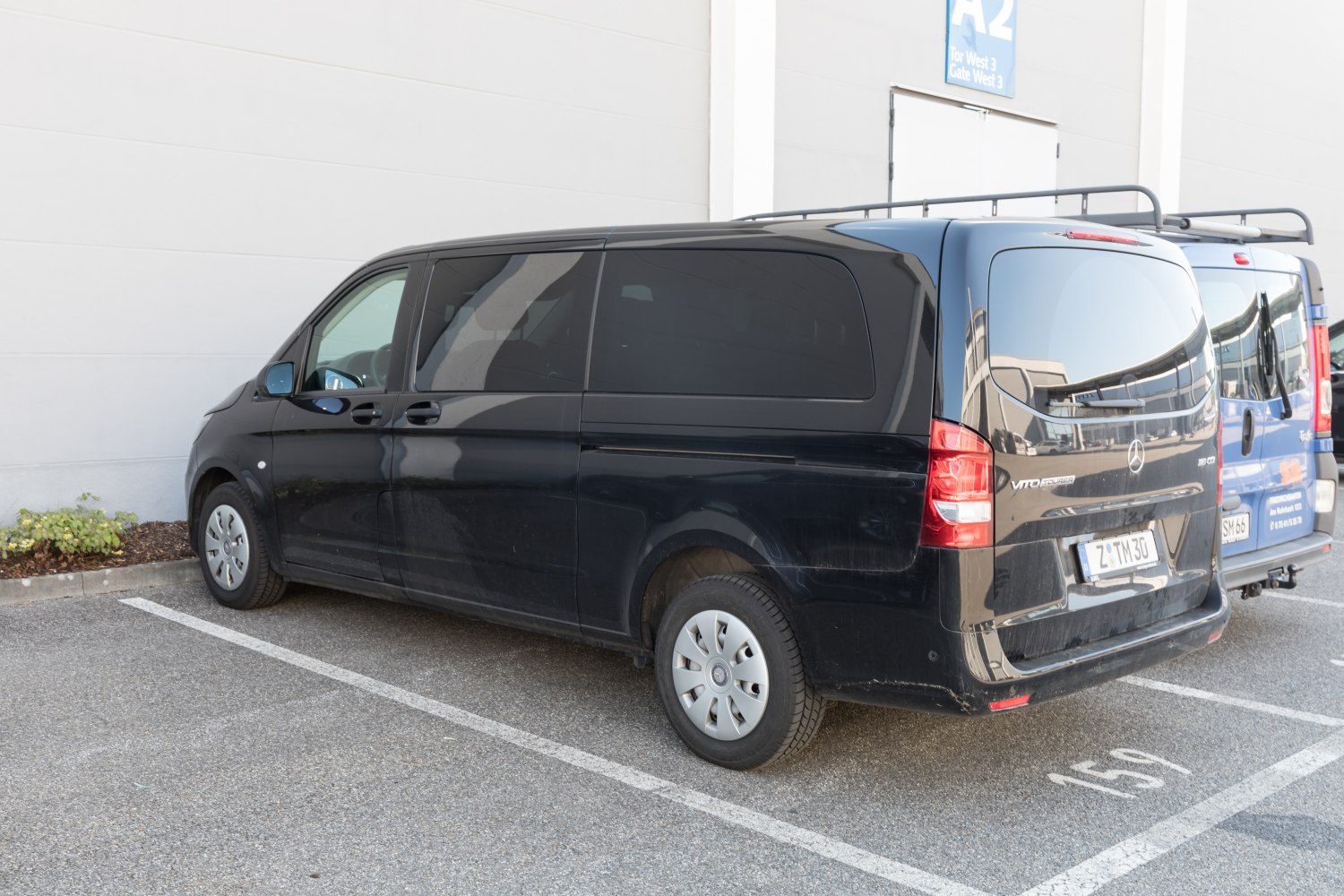 Rear-side view of black extra long van with tinted windows