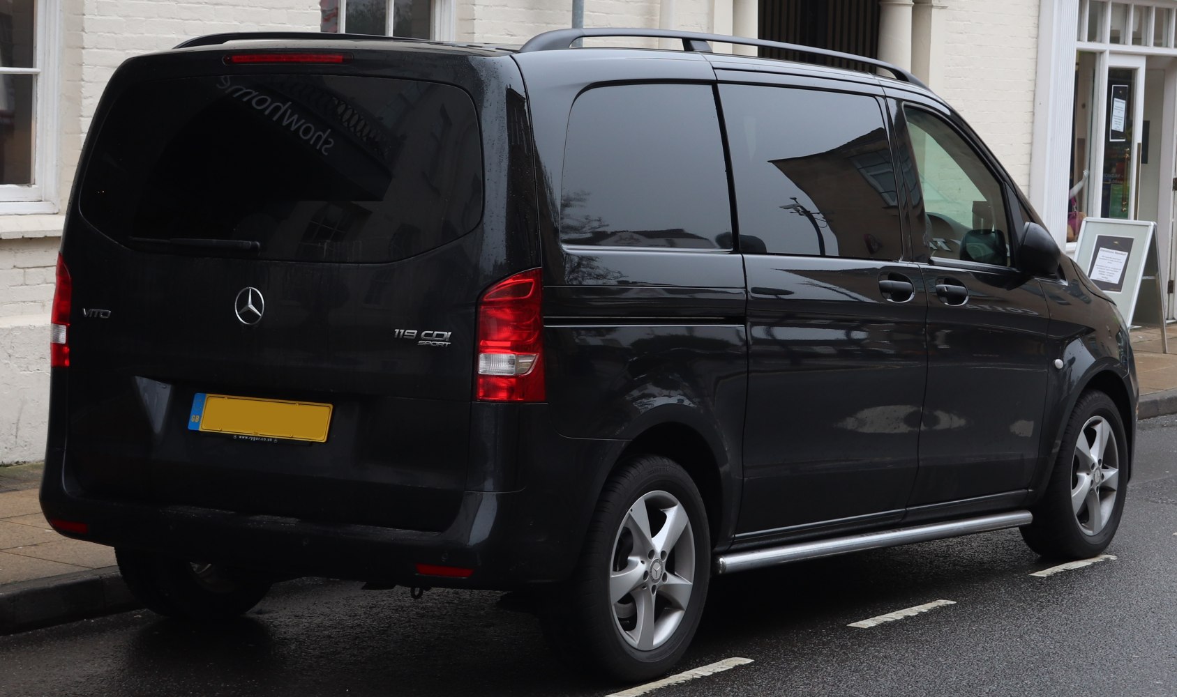 Rear side view of black van with tinted windows and alloy wheels