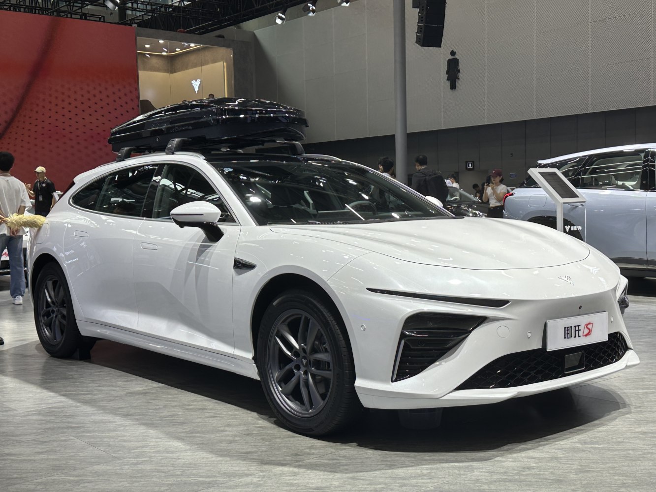 Sleek white car with roof-mounted cargo box and aerodynamic styling