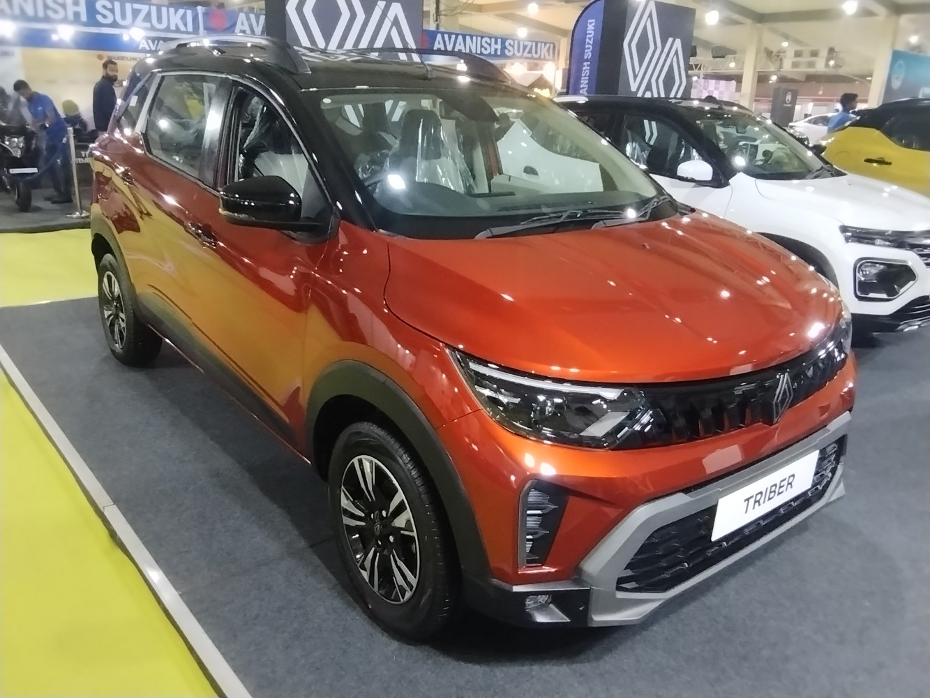 Front view with LED headlights, bold grille, and alloy wheels in orange.