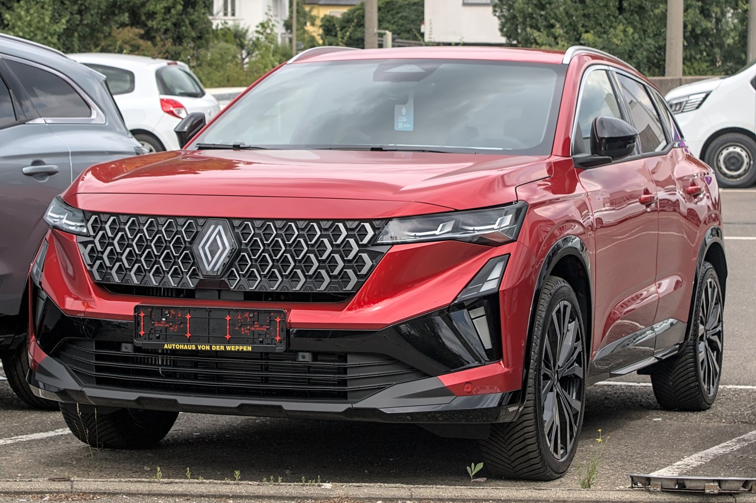 Front hexagonal grille with sleek LED headlights on a red SUV.