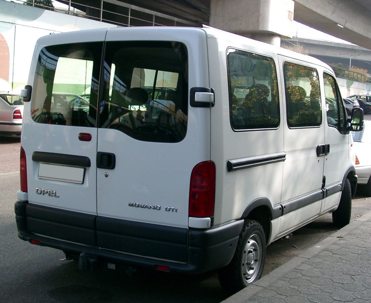 Rear and side view of white passenger van with large windows and black trim
